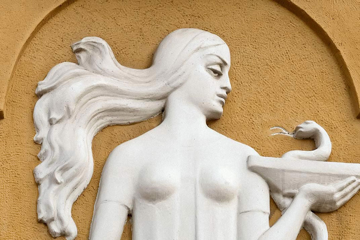 Hygieia, goddess of hygiene, in classical relief — a symbol of wellness, ritual, and refined self-care