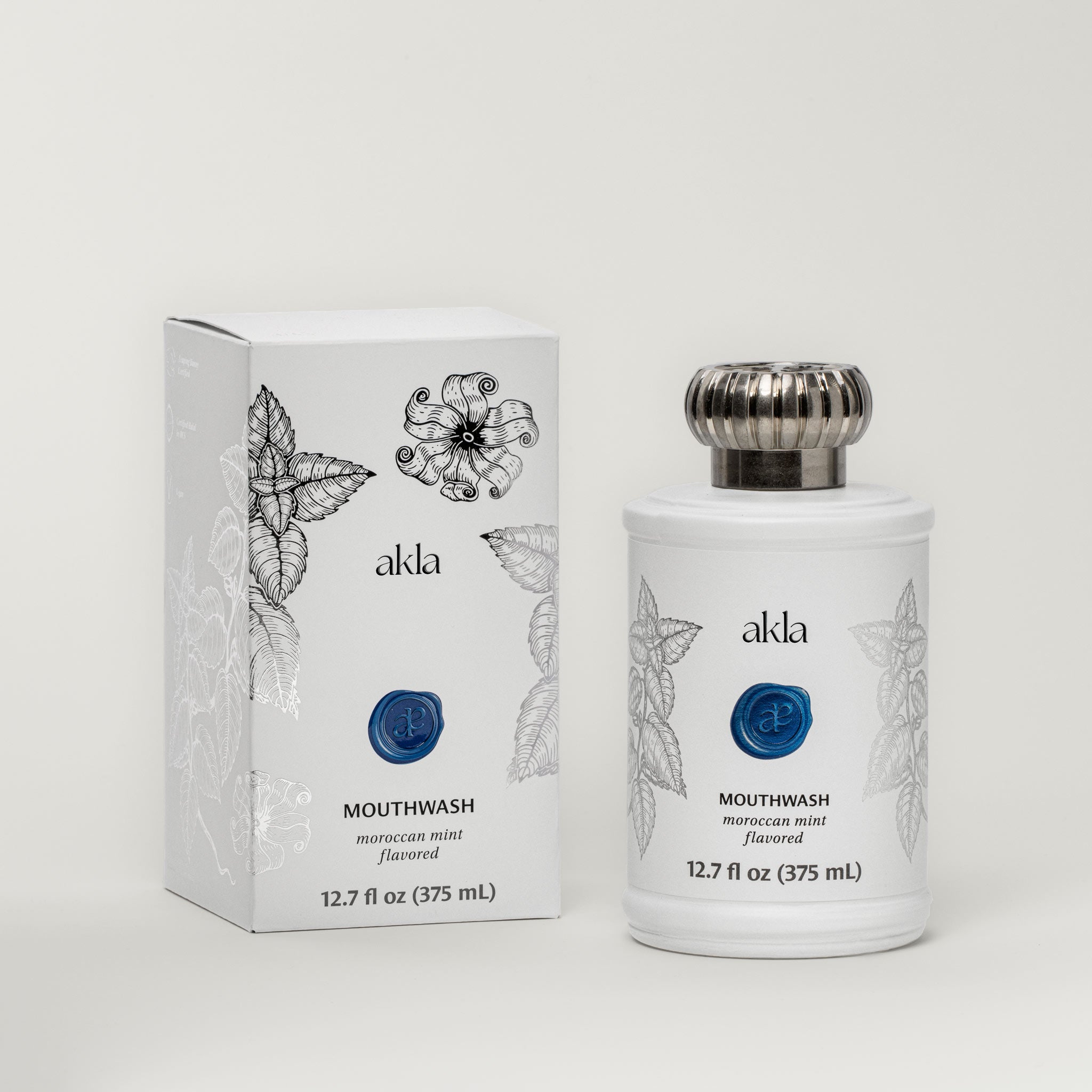 Akla Moroccan Mint Mouthwash – alcohol-free, fluoride-free Swiss oral care with illustrated box and recyclable matte white glass bottle.