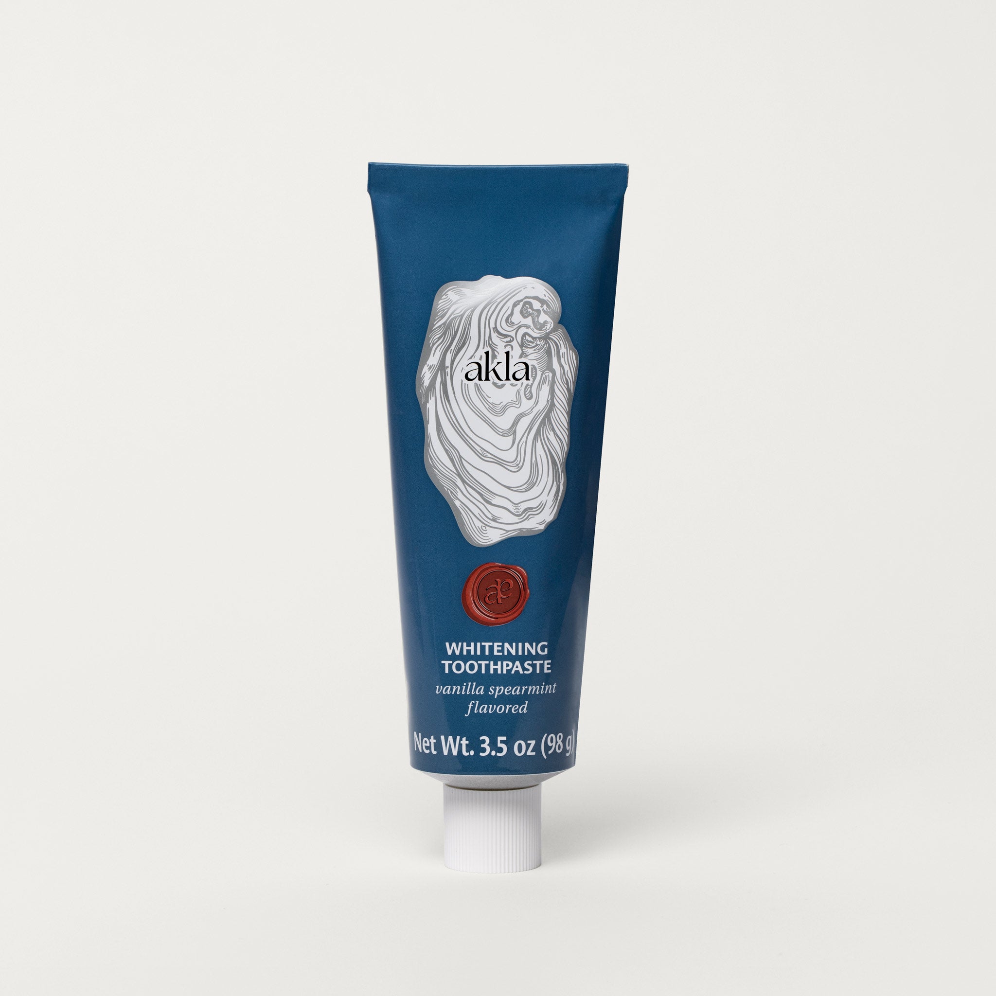 Akla Vanilla Mint Whitening Toothpaste in blue aluminum tube, fluoride-free with nano-hydroxyapatite and pearl powder.