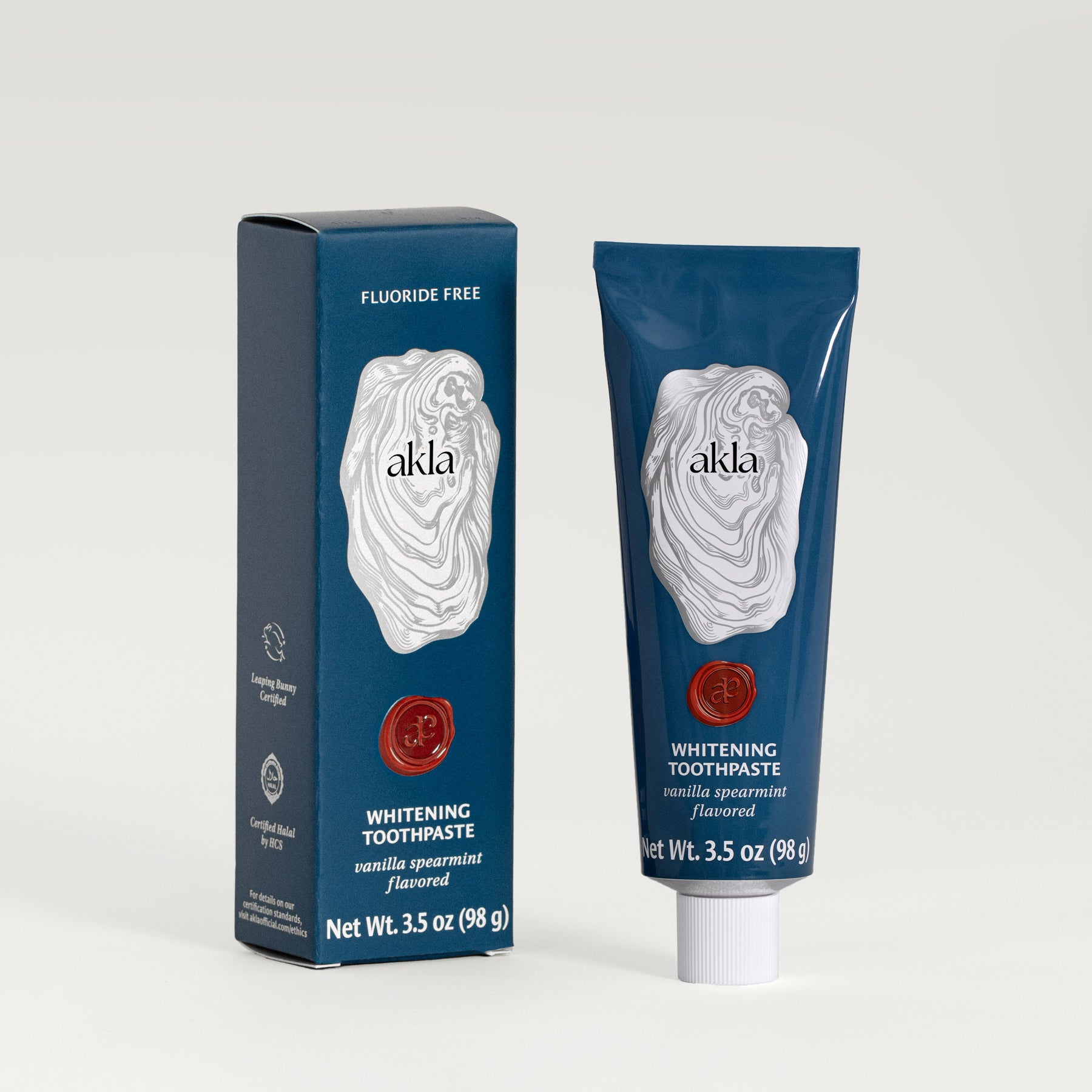 Akla Whitening Toothpaste and box in Vanilla Spearmint flavor, featuring metallic printed oyster illustration and embossed wax look seal.