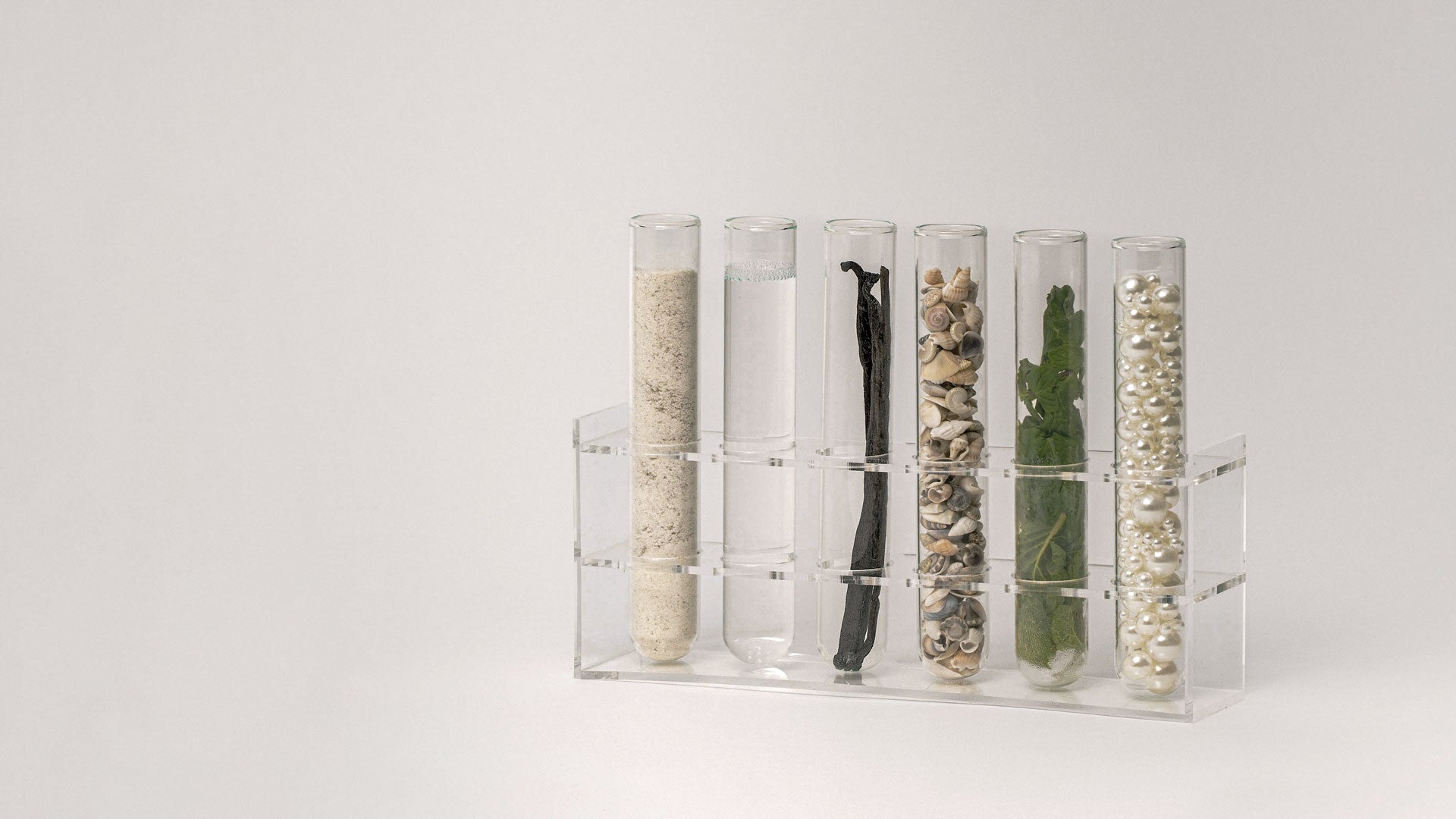 Glass test tubes with Akla hero ingredients hydroxyapatite, glycerin, vanilla flavor, pearl powder from pearls.
