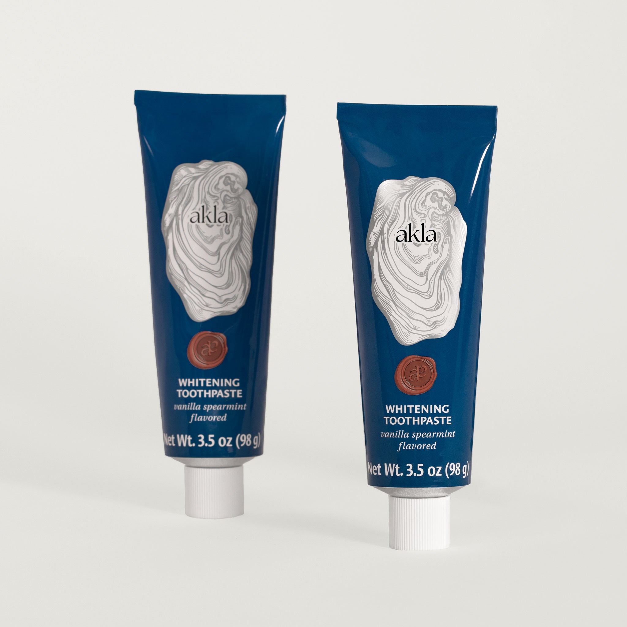 Akla Vanilla Spearmint Toothpaste duo in navy blue aluminum tubes. Fluoride-free non-nano hydroxyapatite toothpaste, formulated in Switzerland.
