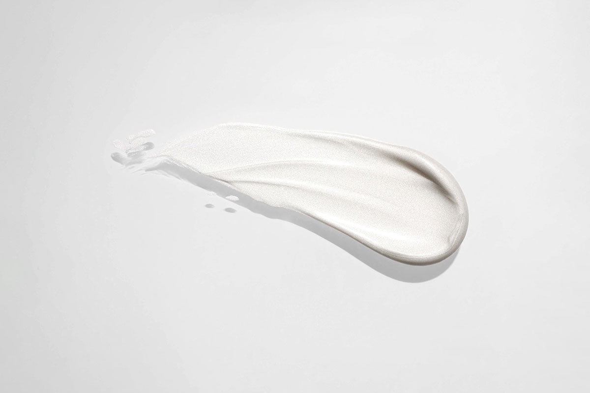 Luxury fluoride-free toothpaste smear with pearlescent texture, symbolizing science and beauty.